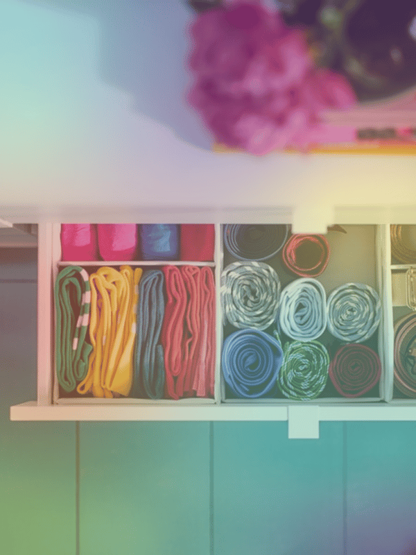 Tiroir avec des vêtements colorés rangés dans des boites d'organisation 