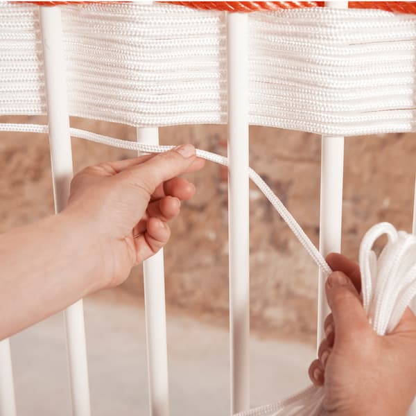 Tissez un bord décoratif entre les barreaux du lit à l’aide d’une corde en nylon épaisse.