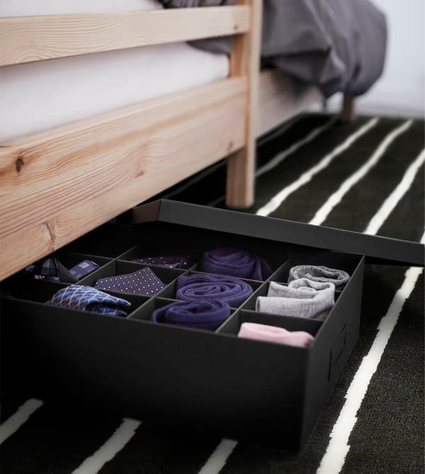 TJENA box with compartments under a bed, with socks and small accessories.