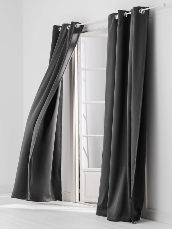 Tmavosivé závesy HILLEBORG vznášajúce sa vo vetre v pootvorenom bielom francúzskom okne.