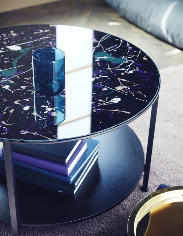 To make a painted glass-top table, you can use a VITTSJÖ coffee table from IKEA. We splatter painted pink, purple and white first. After they dried, we rolled on black to match the table’s modern style.