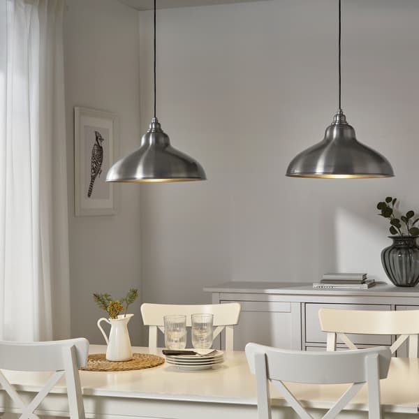 To metallamper over et hvidt spisebord.