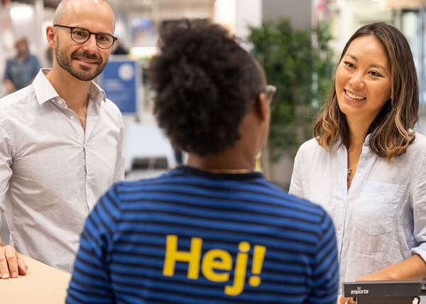 To personer taler med en IKEA medarbejder set bagfra.
