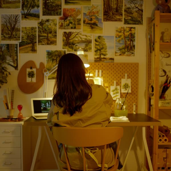 부드러운 화이트 TOFTLUND 토프틀룬드 러그를 바닥에 깔고 앉아 방 안 창문 옆 바닥에서 명상하고 있는 여성.