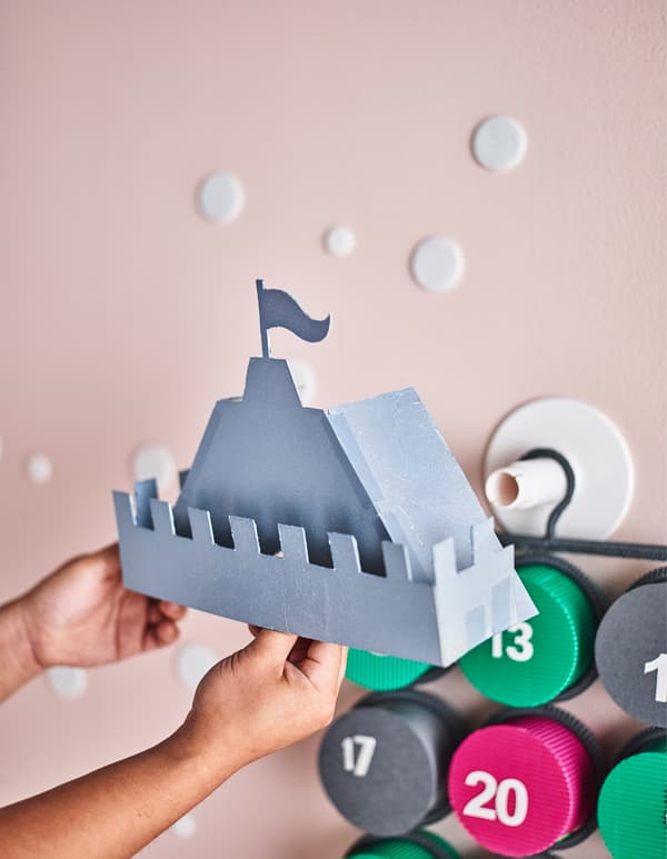 Toit du château en papier, en train d'être collé au calendrier de l'Avent accroché au mur.