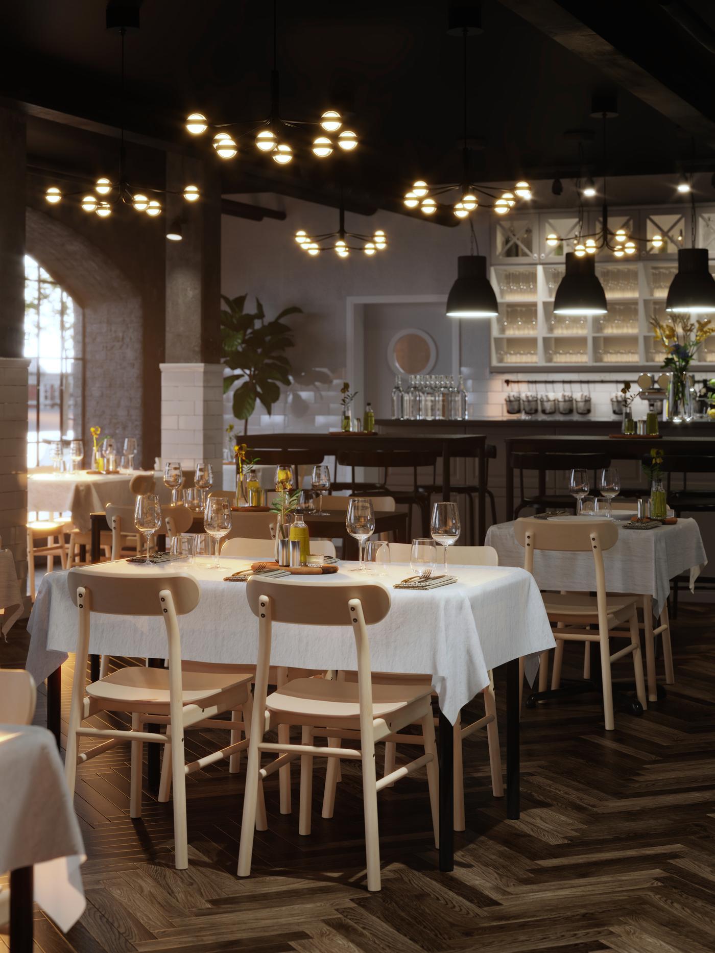 TOMMARYD tables set for dining with white tablecloths, STORSINT wine glasses and flowers in a spacious restaurant with parquet floors.