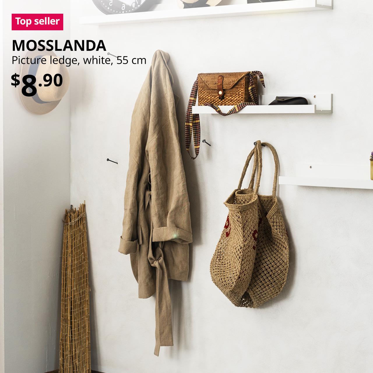 Top seller IKEA product. Main entrance's wall featuring white MOSSLANDA picture ledges, 55 cm, mounted on wall. Price: $8.90