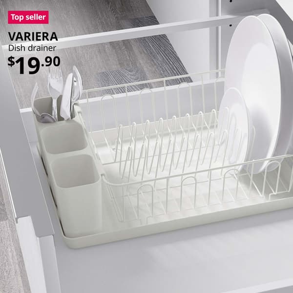 Top seller tag. VARIERA dish drainer placed within a kitchen shelving unit, with a bunch of utensils and white plates placed within the drainer. $19.90.