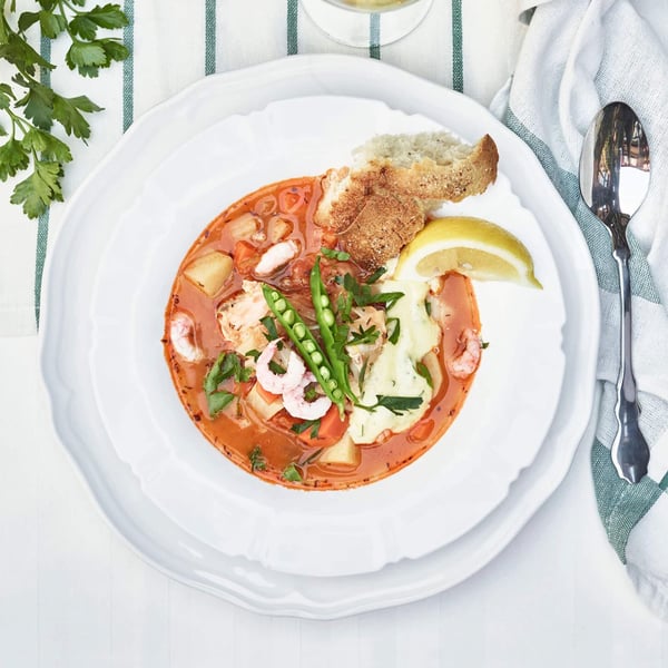 Top view of a bowl of tomato based seafood stew.