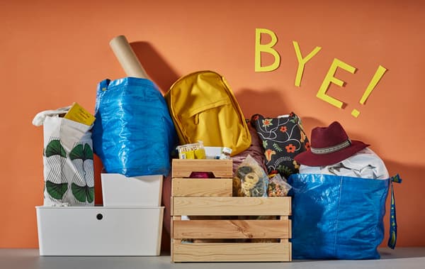 Tout ce qu’il faut pour commencer à la fac, prêt à emporter et posé contre un mur coloré