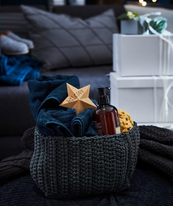 Tovalloles de convidats IKEA VÅGSJÖN presentades com a regal en un cistell de tela.