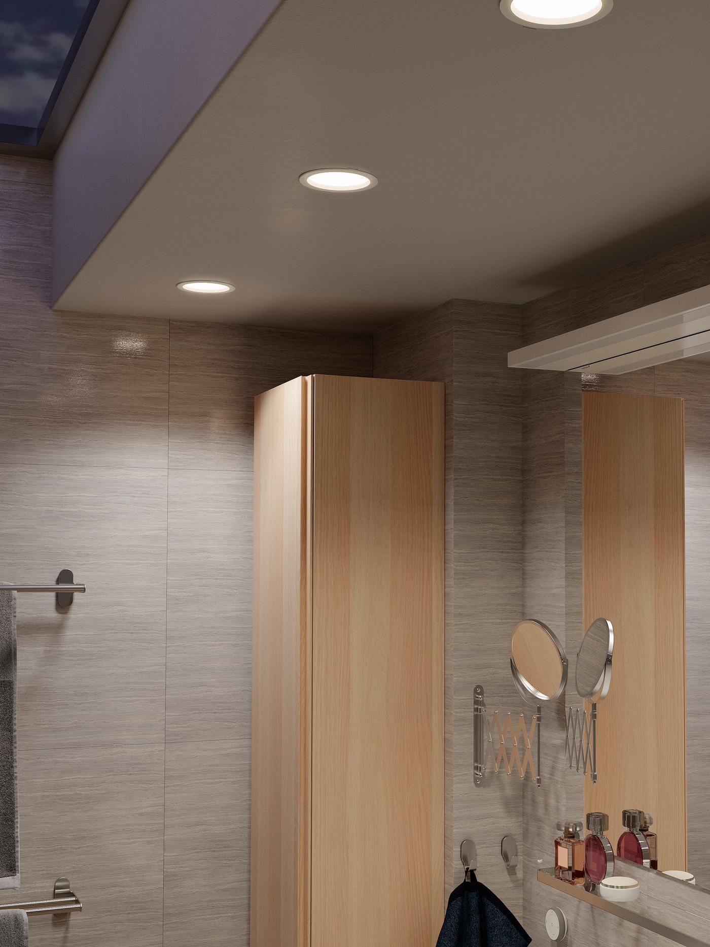 תקרת אמבטיה עם שלושה ספוטים שקועים של נורות לד דימר, שלט TRÅDFRI תלוי על הקיר מתחת.