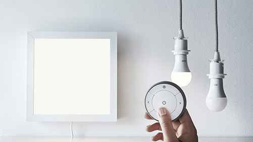TRÅDFRI smart remote control with a lighting panel and two lightbulbs.