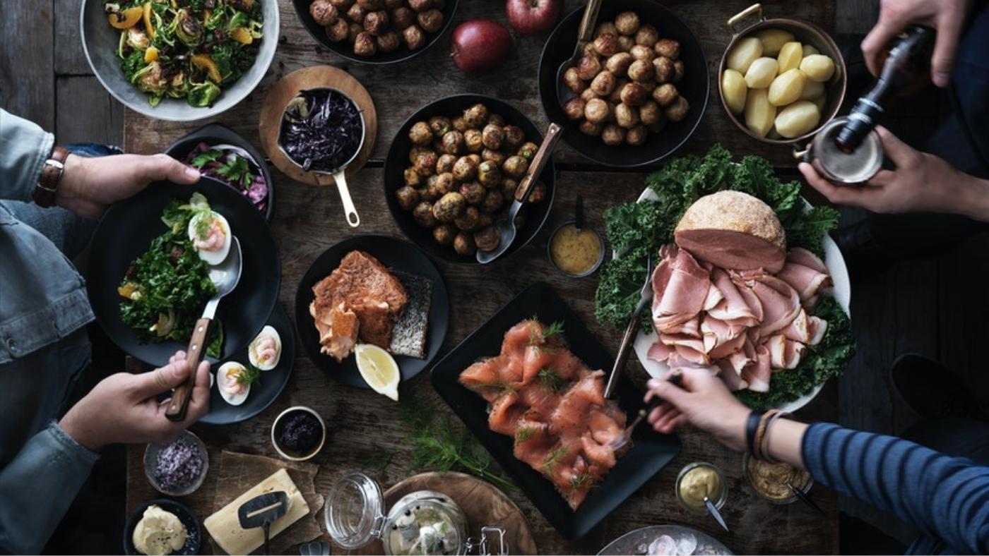 Traditional Swedish julboard, Christmas dinner buffet, three people are serving the food.