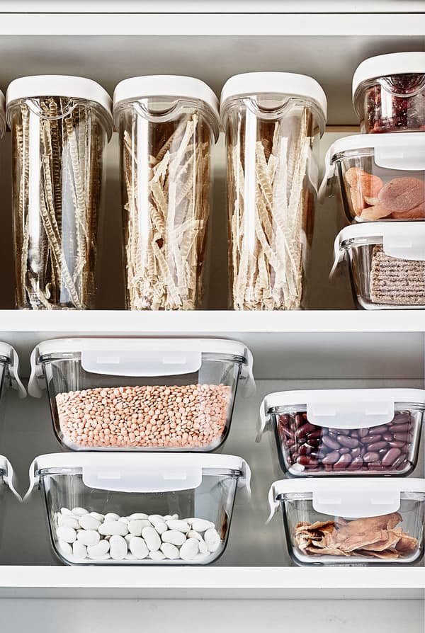 Transparent storage containers make it easy to see cereals and other dry products in this kitchen cabinet.