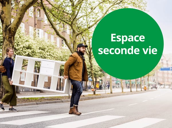 Transport d’un meuble réutilisable à travers un passage piéton arboré, illustrant l’Espace seconde vie et l’économie circulaire.