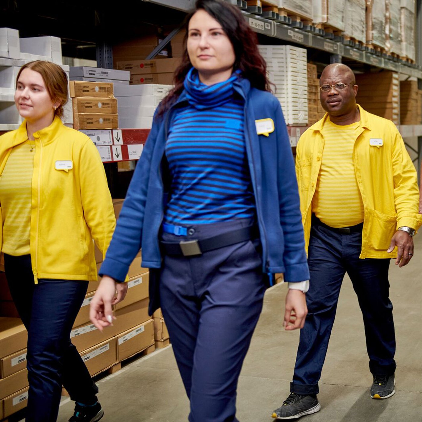 Tre IKEA medarbejdere med forskellige etniciteter går i en flok inde på et Ta' selv lager.