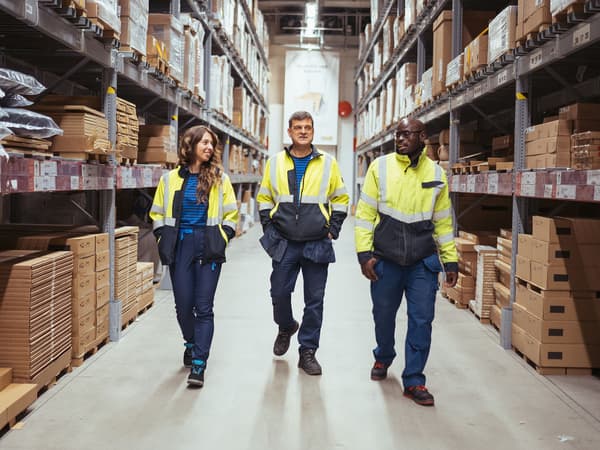 Tre medarbejdere fra Logistik går i gangen mellem reolerne på Tag Selv Lageret.