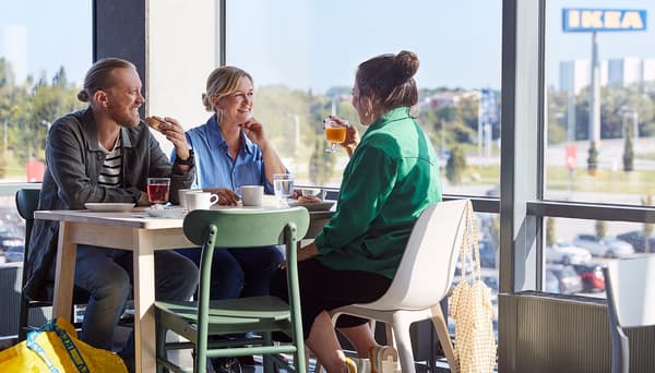 Tre personer sitter i restauranten og spiser.