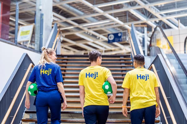 Tres colaboradores de IKEA subindo as escaleiras dunha das tendas.