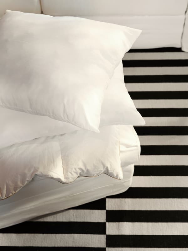 Tri LAPPTÅTEL jastuka i kremasti GRÖNLID ukrasni jastuk za sofu na prugastom STOCKHOLM tepihu.