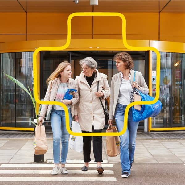 Tri žene na pešačkom prelazi ispred ulaza u IKEA robnu kuću.