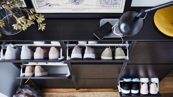 Trois armoires à chaussures BISSA en brun-noir. Plusieurs de leurs trois compartiments dévoilent plusieurs paires de chaussures.