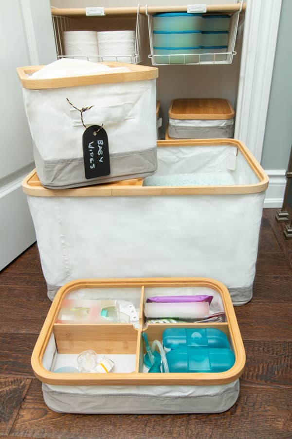 Trois boîtes RABBLA avec couvercle en bambou. La boîte compartimentée contient des articles pour bébé.