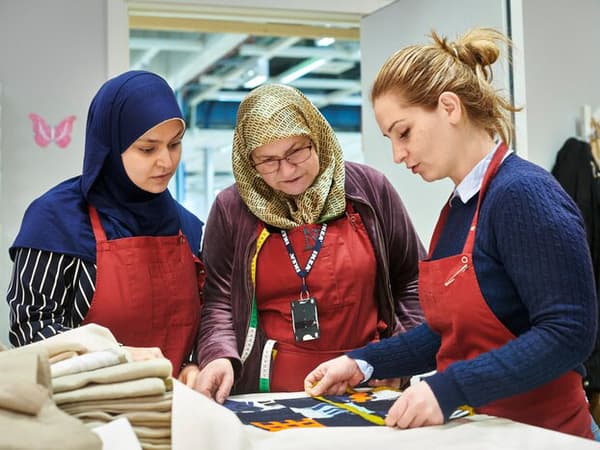 Trois collaboratrices de l’atelier de couture Yalla Trappan du magasin IKEA de Malmö (Suède) mesurent du tissu.