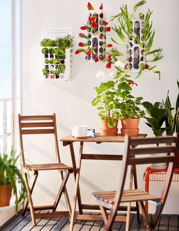 Trois distributeurs de sacs plastique VARIERA fixés au mur du balcon et utilisés comme jardinières.