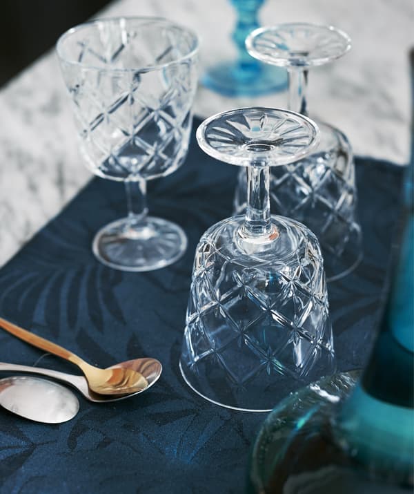 Trois verres à vin en verre taillé sur la table de salle à manger.