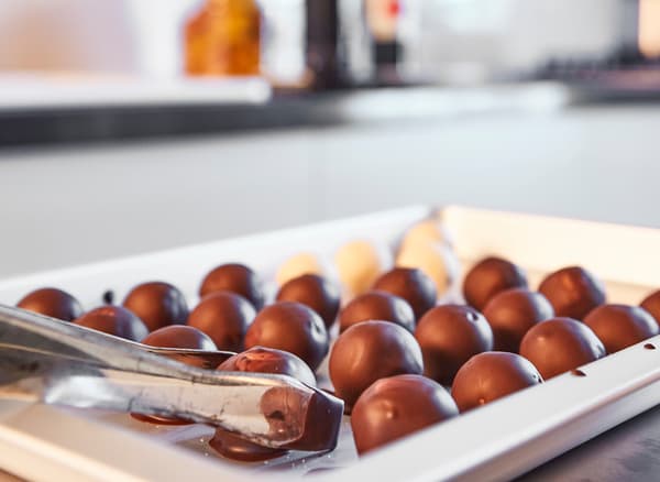 Truffes au chocolat tout juste confectionnées disposées sur un plat de service blanc.