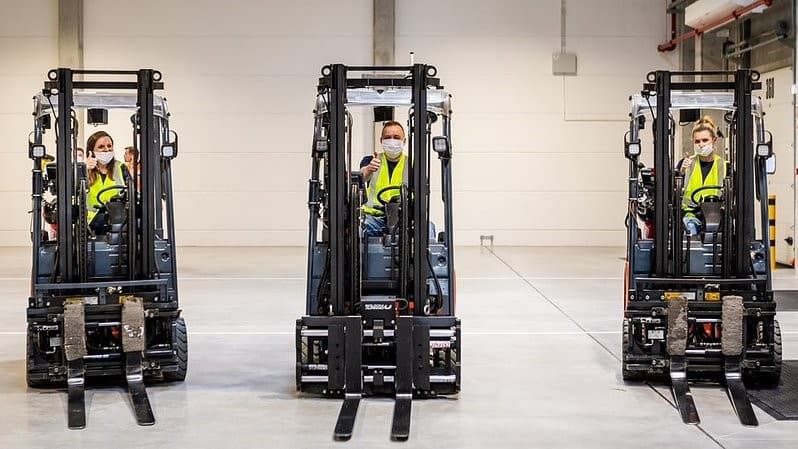 Trzy wózki widłowe, w których siedzą pracownicy IKEA