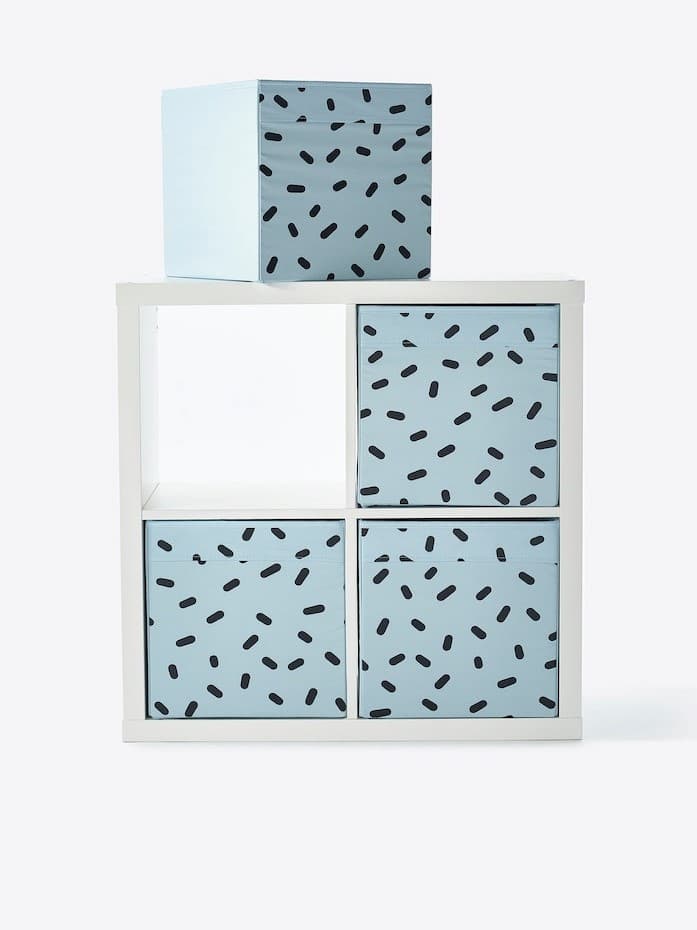 Turkusowe pudełka w białym regale.