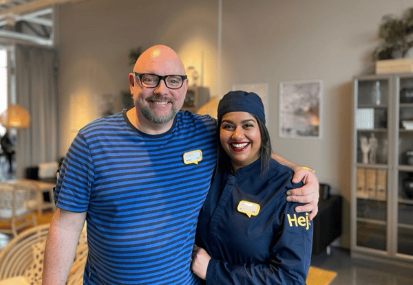 Två glada IKEA medarbetare som poserar och ler för kameran