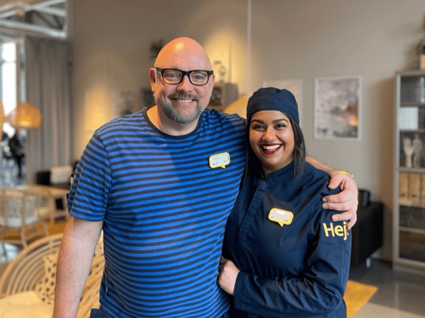 Två glada IKEA medarbetare som poserar och ler för kameran