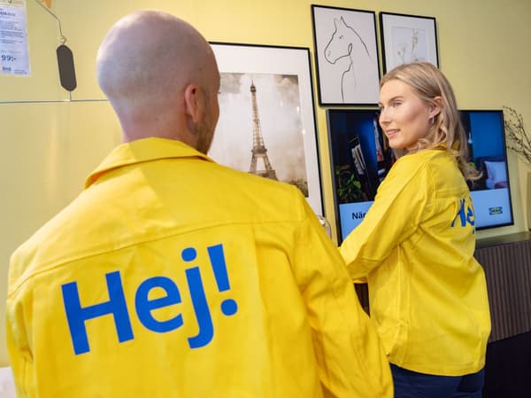 Två IKEA medarbetare som pratar med varandra