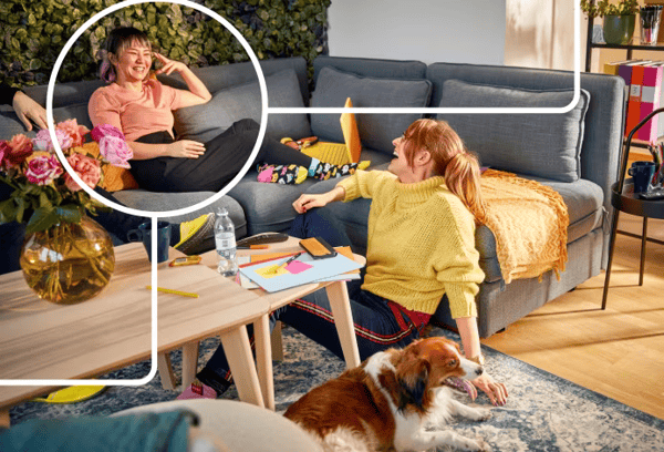 Två kvinnor och en hund som sitter ner i en avslappnad miljö.