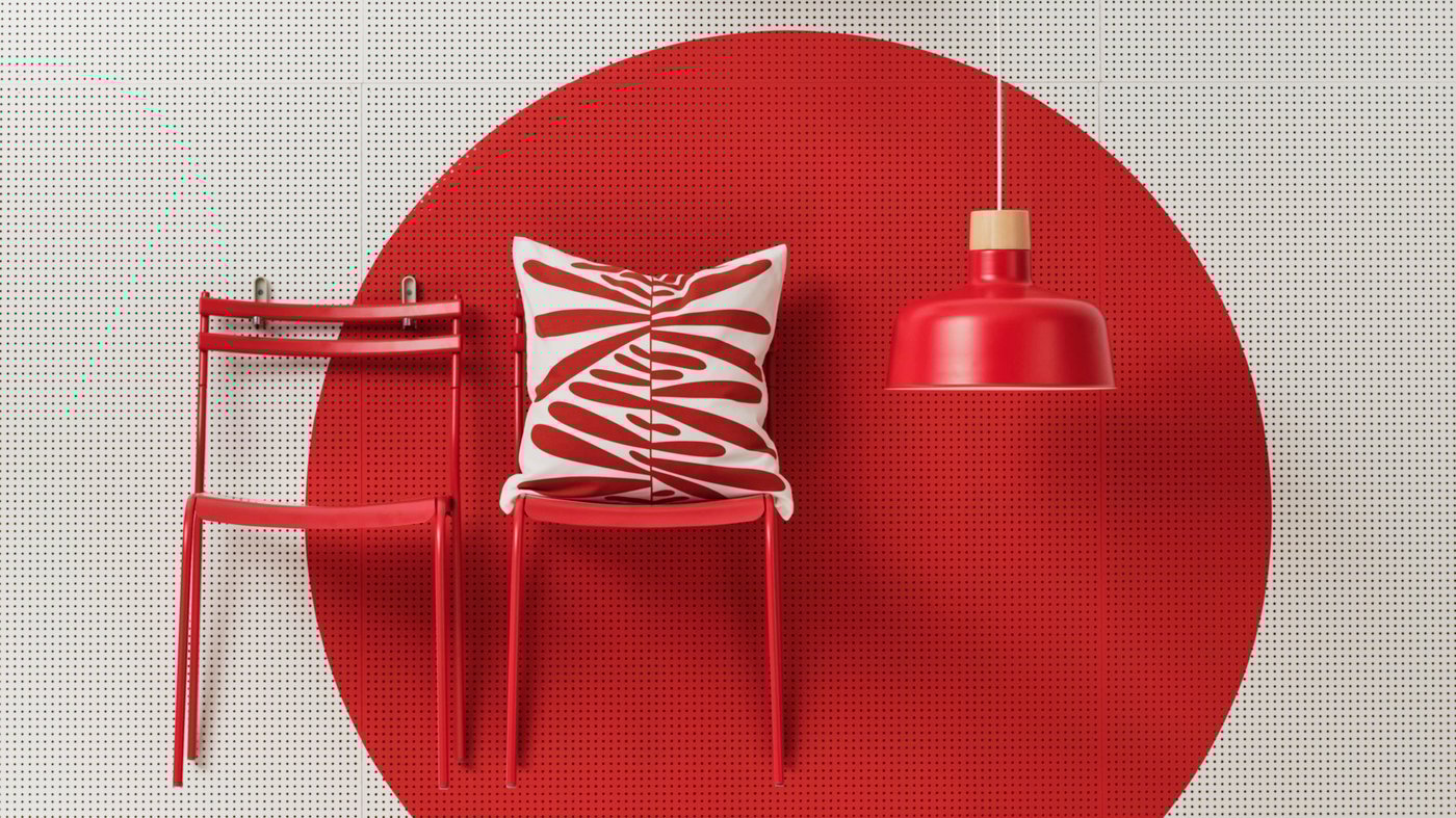 Två röda stolar och en röd lampa står framför en vit vägg med en röd cirkel på. 