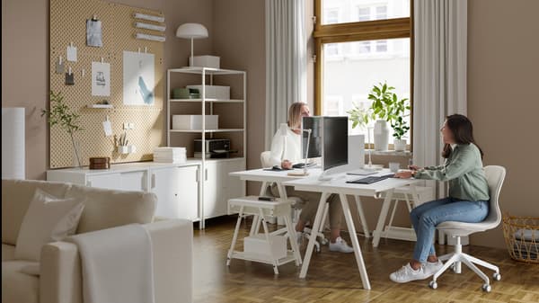 Twee mensen aan allebeie aan een bureau zitten tegenover elkaar.