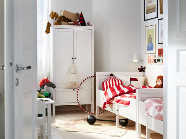 Twee SUNDVIK meegroeibedden staan tegen de wand met de uiteinden tegen elkaar aan vlak bij een witte SUNDVIK kast in een slaapkamer.