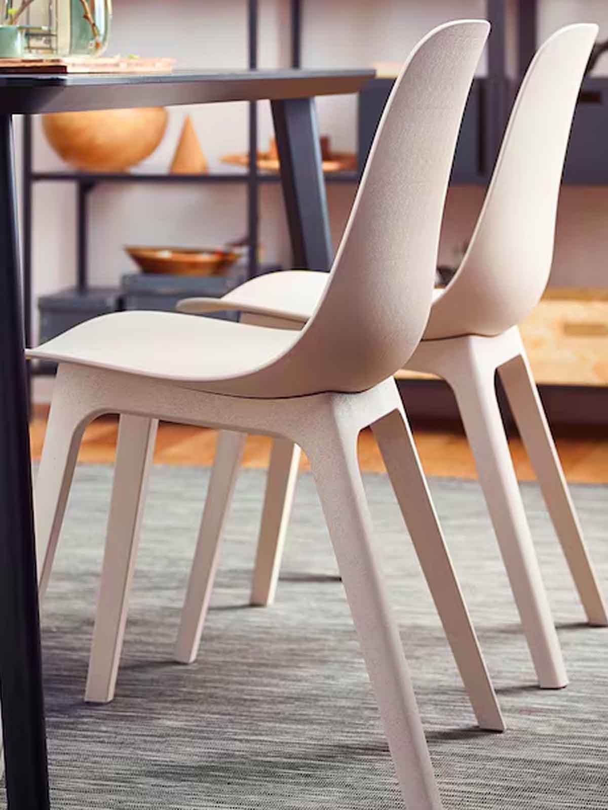 Two beige ODGER dining chairs tucked under a dining table in the dining area of the home.