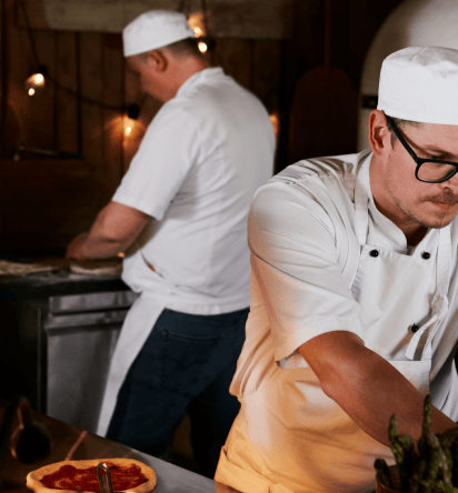 Two chefs in white hats working in the kitchen