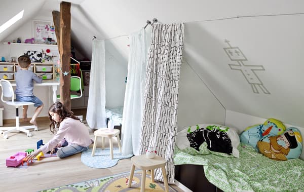 Two children playing in a shared bedroom.