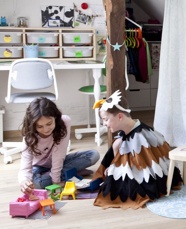 Two children playing on the floor of their shared bedroom.