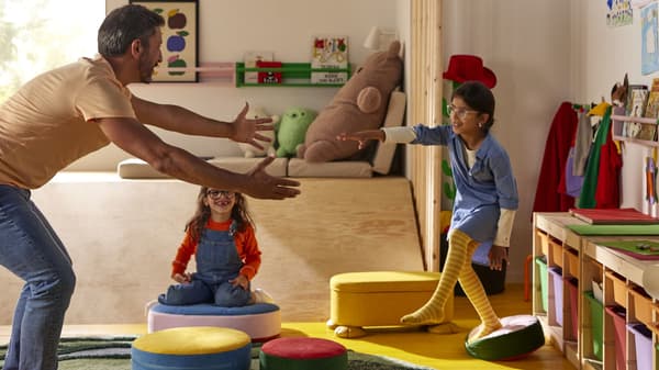 Two children playing with toys and opening a toy box.