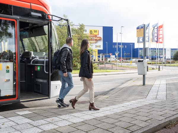 Two costumers getting off the bus in front of an IKEA store