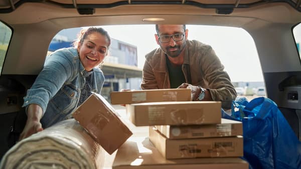 two customers loading IKEA product into the back of a vehicle