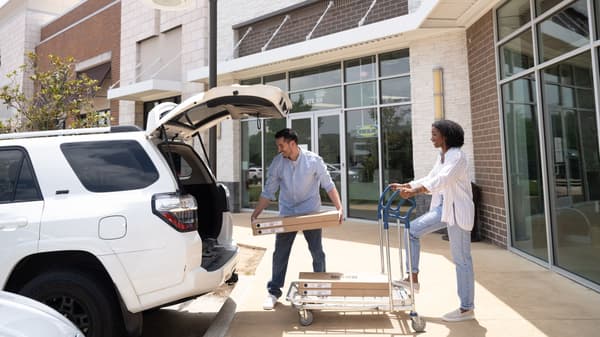 Two customers loading IKEA products into the back of a truck
