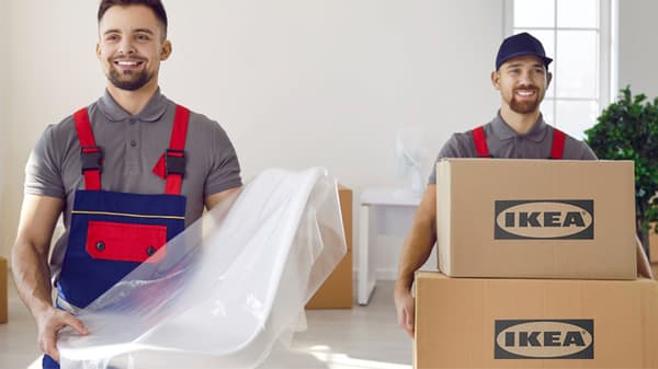 Two delivery men dropping off IKEA products into a customers home.